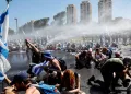 Demonstrators are sprayed with a water cannon during a demonstration against Israeli Prime Minister Benjamin Netanyahu and his nationalist coalition government's judicial overhaul, in Jerusalem July 24, 2023. REUTERS/Ammar Awad